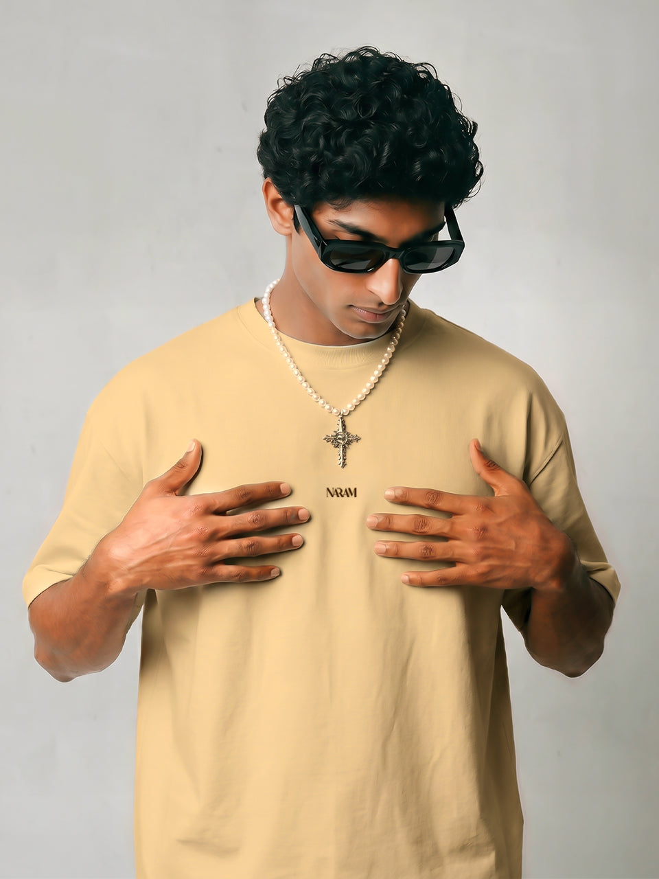 Close-up of Naram chest logo on beige oversized t-shirt  minimal Indian streetwear identity