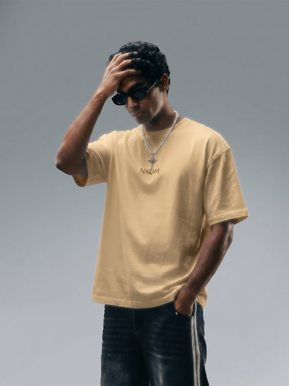 Naram oversized beige t-shirt worn by man styled with accessories Indian streetwear brand