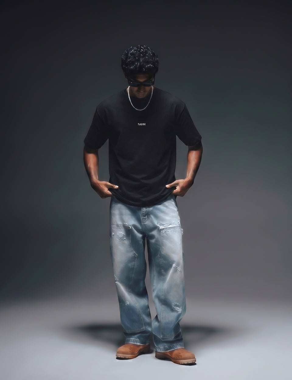 Full body shot of Naram black oversized t-shirt with wide-leg distressed jeans and brown boots desi streetwear
