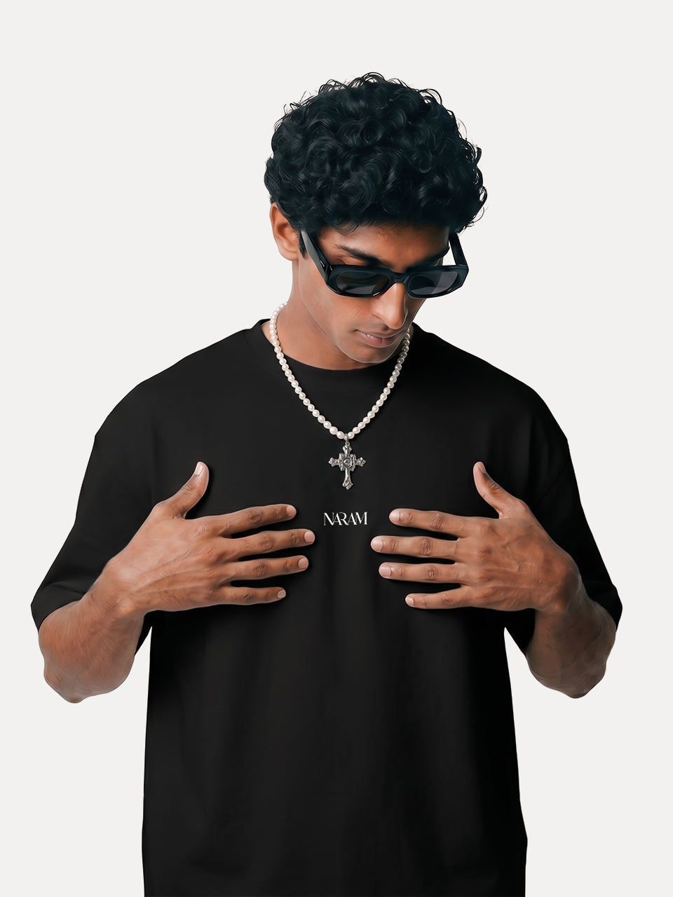 Front view of Naram black oversized tshirt with white Naram chest logo, styled with pearl chain, Indian streetwear