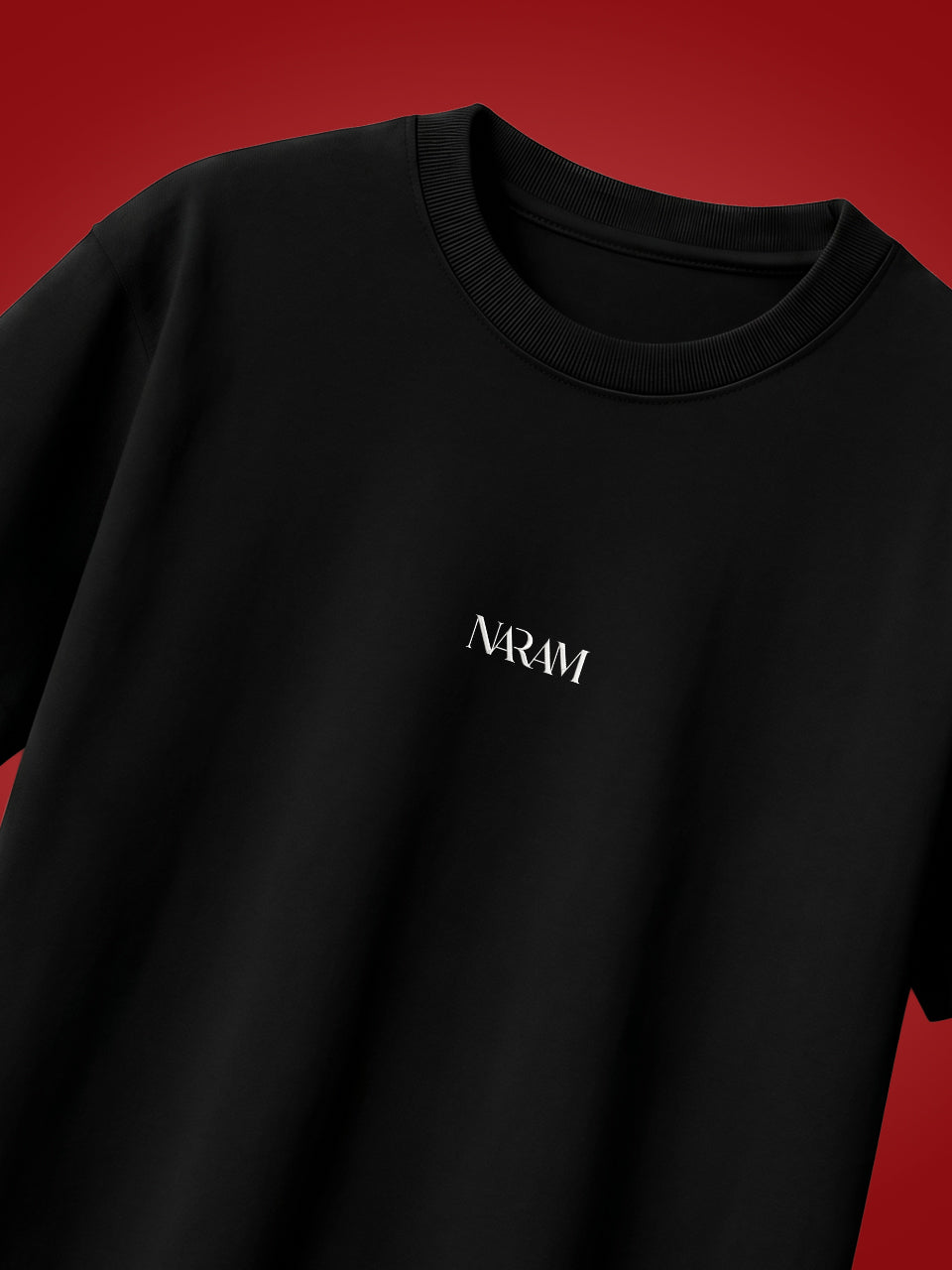 
Naram Eagle oversized tshirt black front flat lay with white Naram logo on red background, product photography