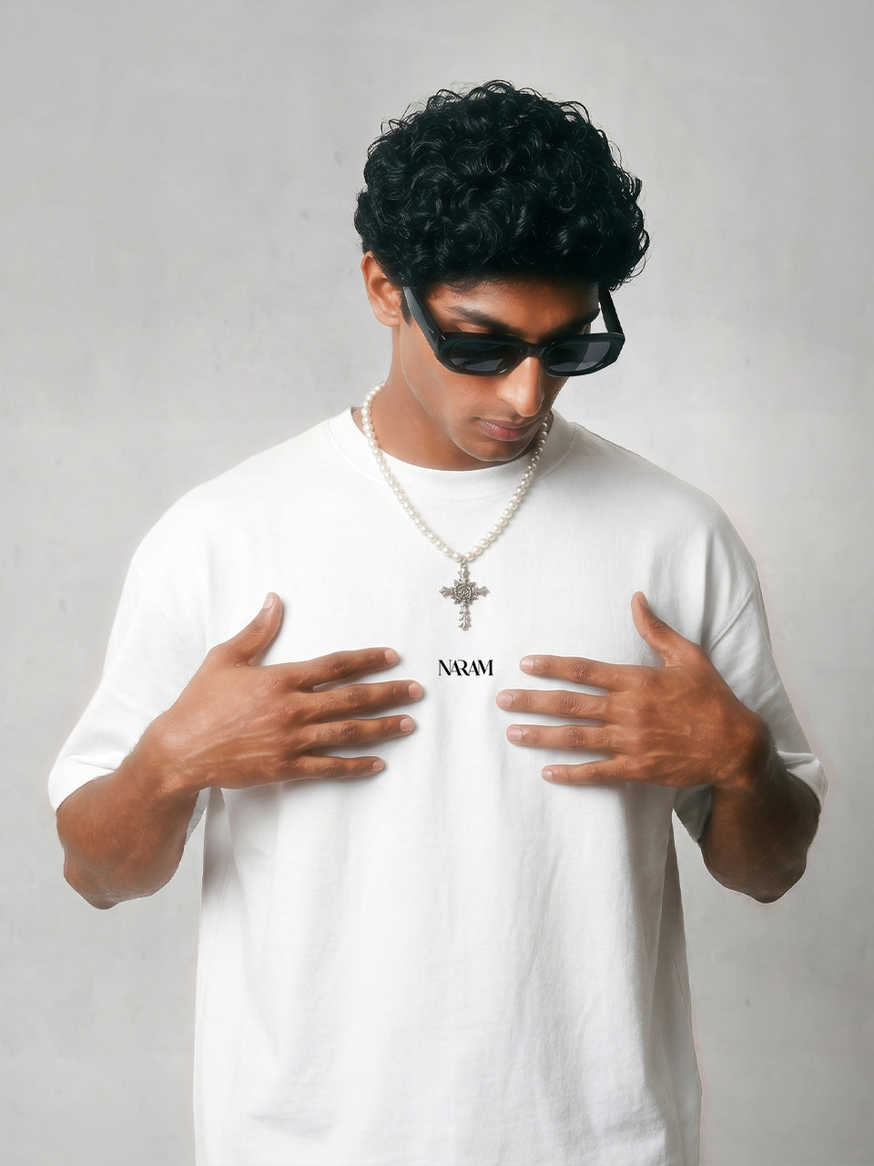 Close-up of Naram chest logo on beige oversized t-shirt minimal Indian streetwear identity