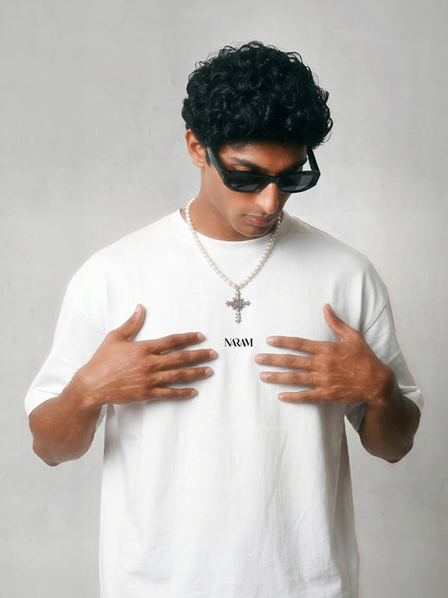 Close-up of Naram chest logo on beige oversized t-shirt minimal Indian streetwear identity