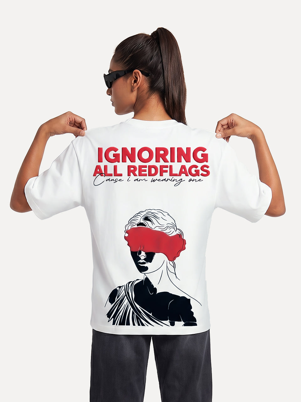 Back view of Naram Red Flag white oversized tshirt on female model showing bold red puff print Ignoring All Redflags text and blindfolded woman graphic, Indian streetwear
